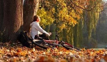 11043902-relaxes-woman-cyclist-with-bike-sits-among-fallen-leaves-autumn-morning-in-nature-illuminated-by-the_0.jpg